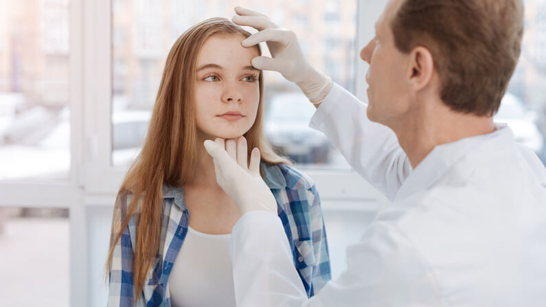 A doctor checking up the acne of young lady skin cancer specialist dermatology treatment with doctor fakouri in texas