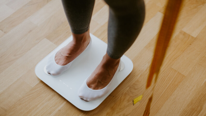 Woman wearing white foot socks on a weighing scale