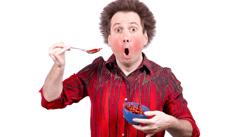 Man eating a bunch of red chili 